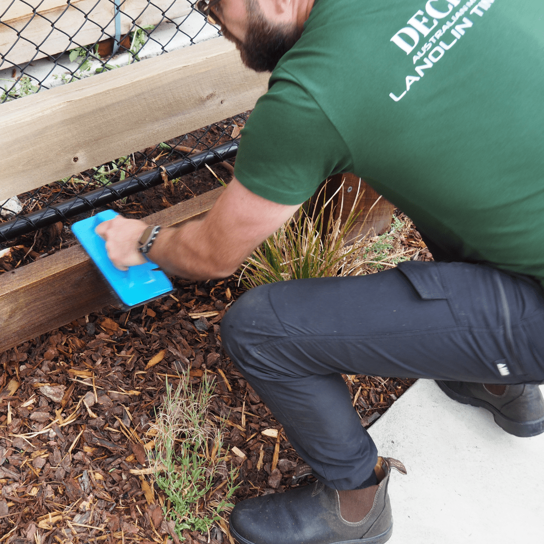 Deck Doc Technician Oiling Fence with Applicator