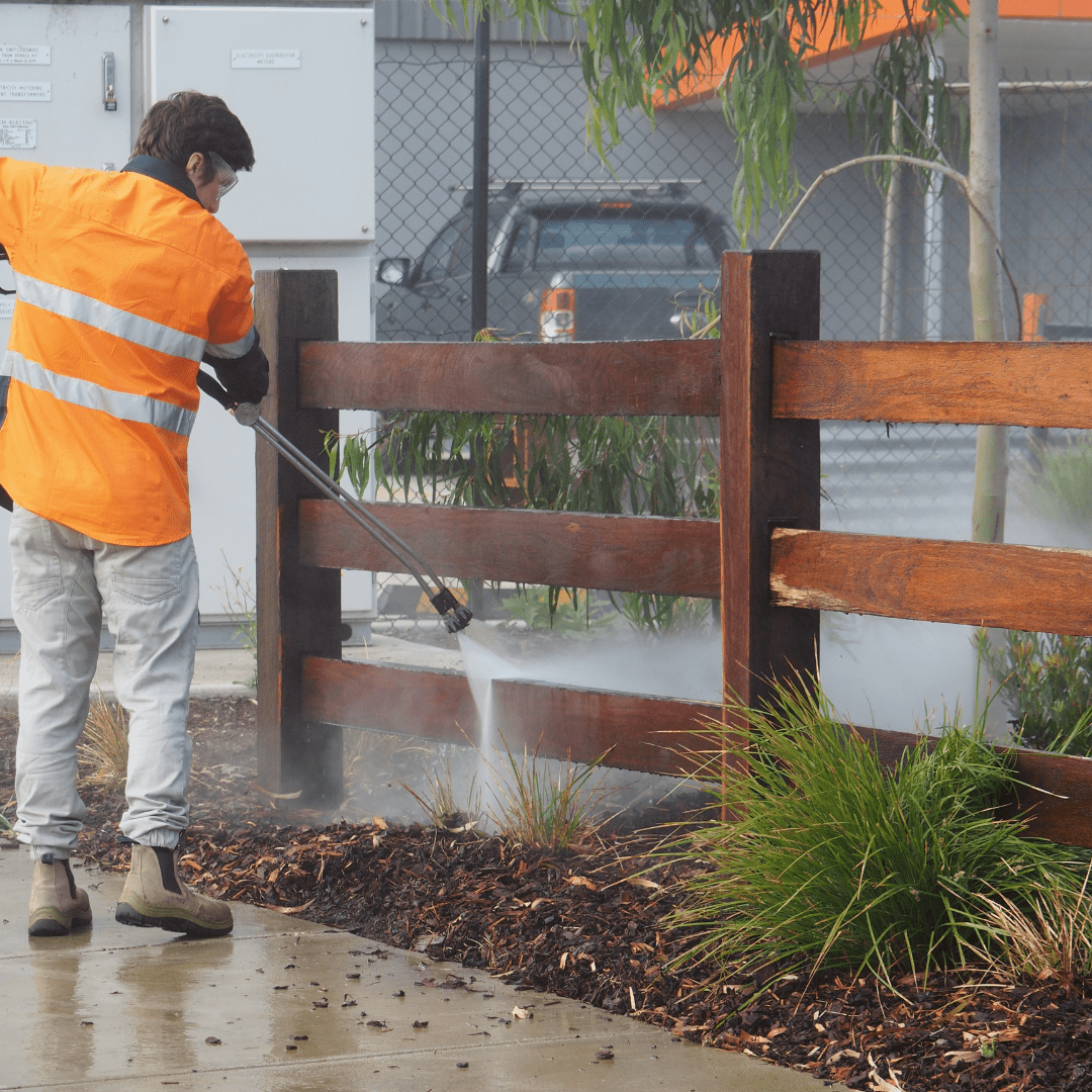 Technician Pressure Cleaning Timber Fence