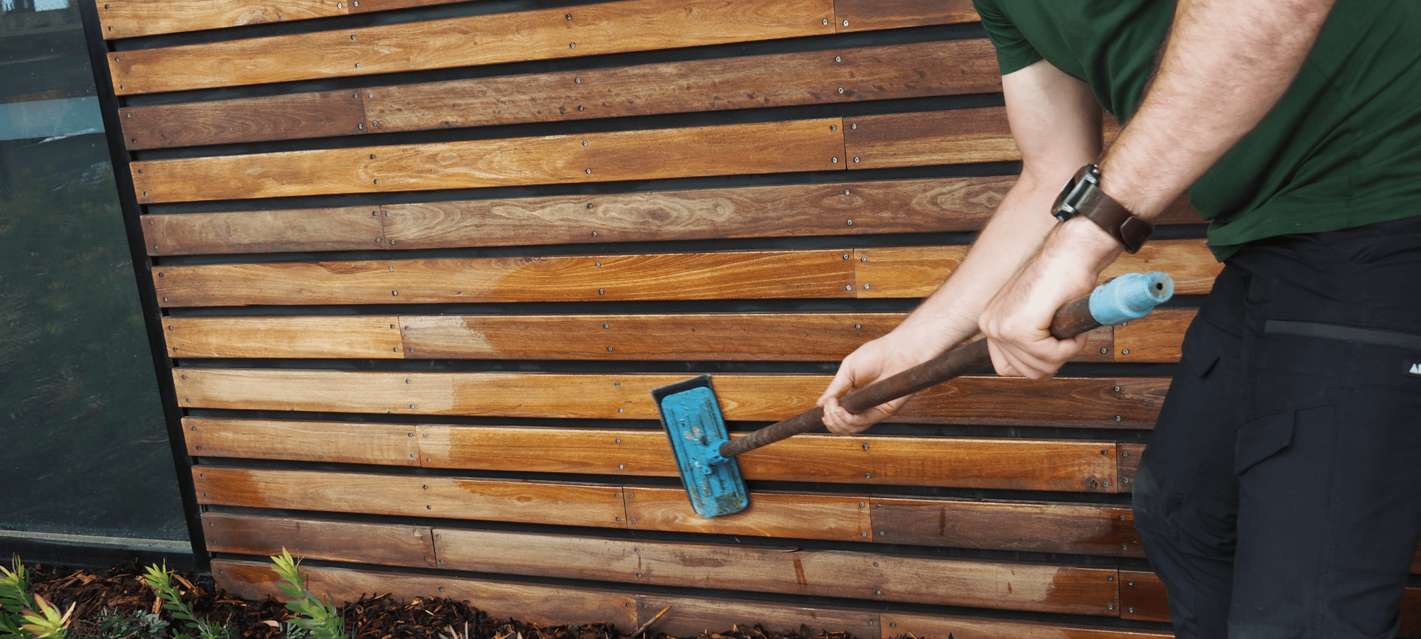 Technician Oiling Timber Cladding With Deck Doc Applicator
